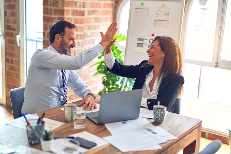 Two people sitting across a desk in a bright office during a conversation